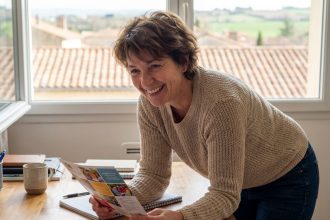 Femme souriante étudie un prospectus coloré dans un bureau