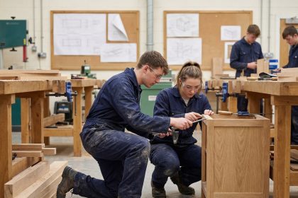 Jeunes en atelier de menuiserie assemblant un meuble en bois